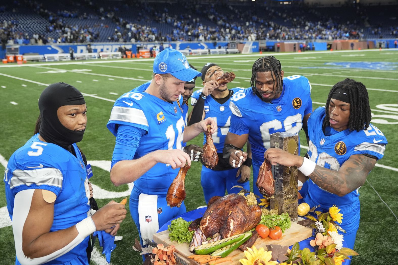 Lions players eating turkey and carrots after the Thanksgiving game