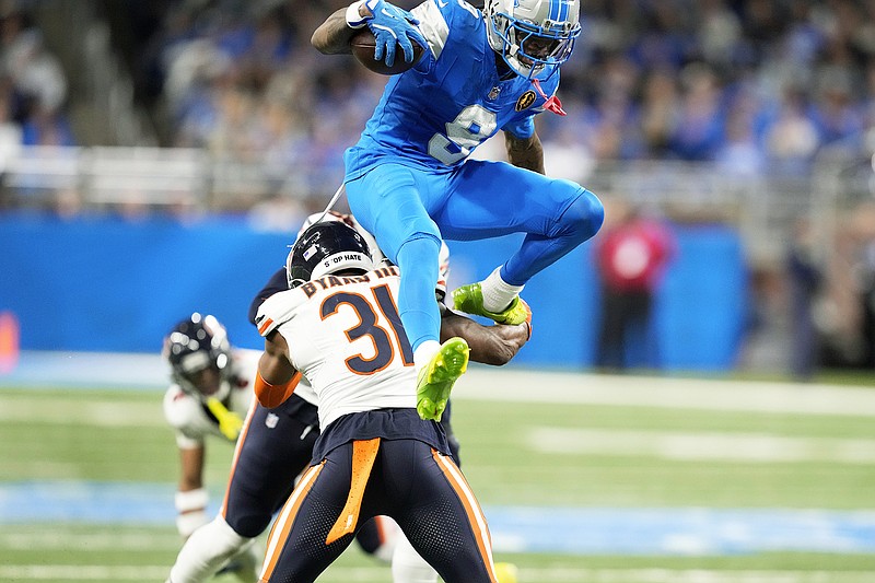 Detroit Lion wide receiver Jameson Williams jumping over player